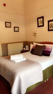 a bedroom with two beds with white sheets at Kinder Lodge in Hayfield