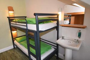 two bunk beds in a bathroom with a sink at YHA Keswick in Keswick