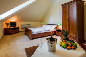 Schlafzimmer mit einem Bett mit einer Schale Obst und Weingläsern in der Unterkunft Dworek 1885 in Schildberg