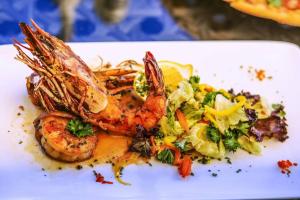 a plate of food with shrimp and vegetables on it at WIN 5 Hotels & SPA in Kampala