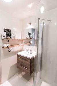 een badkamer met een wastafel en een douche bij Blauwe Lucht in Deurne