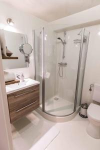 een badkamer met een douche, een wastafel en een toilet bij Blauwe Lucht in Deurne