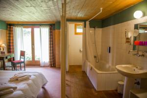 La salle de bains est pourvue d'un lit, d'une baignoire et d'un lavabo. dans l'établissement Hôtel Plein Ciel, à Champéry