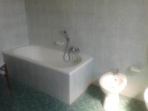 a bathroom with a bath tub and a toilet at Residence Gnura Momma in Locri