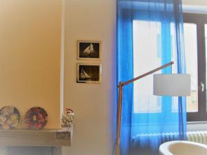 a bathroom with a blue curtain and a window at A 20 mt dal mare con ombrellone e sdraio in spiaggia in Castiglioncello