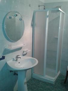 a bathroom with a sink and a shower with a mirror at Residence Gnura Momma in Locri
