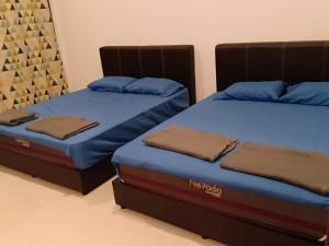 duas camas sentadas uma ao lado da outra num quarto em 2sty Villa - Walking Distance To The Beach em Pangkor