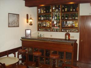 a bar with wooden stools and alcohol bottles at Hotel Sinagoga in Tomar +18 photos