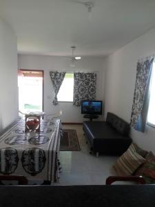 a living room with a black couch and a tv at Paraiso de lazer e festa. in Maricá