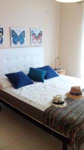 een slaapkamer met een bed met blauwe kussens en vlinders aan de muur bij Sunny apartamento in Portimão