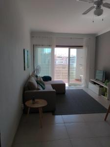 een woonkamer met een bank en een tafel bij Sunny apartamento in Portimão