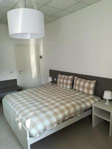 a bedroom with a bed with a checkered blanket at Como Rooms & Apartments T.10 in Como
