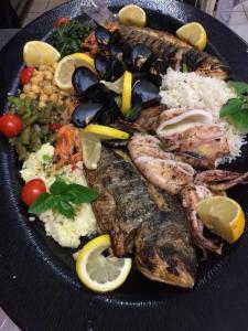 une plaque de nourriture avec du riz et des légumes à base de poisson dans l'établissement Enalion Hotel, à Kala Nera