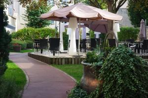 a patio with an umbrella and tables and chairs at Maison Philippe Le Bon in Dijon