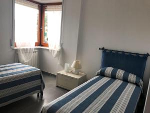 1 dormitorio con 2 camas y mesita de noche con lámpara en GIOBEA New Aptm with A/C en Monterosso al Mare
