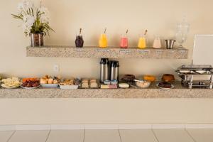 a counter with many different types of food on it at Iron Flat Residence Service in São Gonçalo do Rio Abaixo