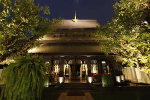 um edifício à noite com árvores em frente em Makka Hotel em Chiang Mai