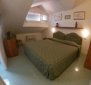 ein Schlafzimmer mit einem grünen Bett in einem Zimmer in der Unterkunft Hotel Locanda del Passo Pomposa in Pomposa