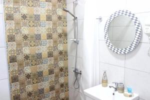 a bathroom with a shower with a mirror and a sink at Apartment Kutaisi in Kutaisi +10 photos