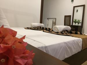 two beds in a room with towels on them at Bay Hiriketiya in Hiriketiya