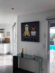 a living room with a tv and a picture on the wall at 3 Impasse Louis Bassède in Argelès-sur-Mer