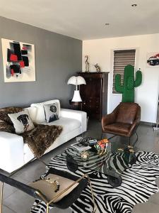 a living room with a white couch and a cactus at 3 Impasse Louis Bassède in Argelès-sur-Mer