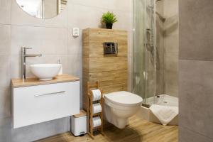 ウッチにあるNettuno Aparts - Manufakturaのバスルーム(トイレ、洗面台、シャワー付)
