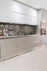 a white kitchen with white cabinets and appliances at MINERVA GUEST HOUSE in Pavia