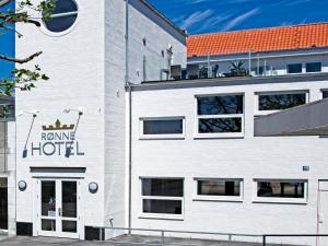 a white building with a hotel sign on it at Rønne Hotel in Rønne