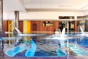 a swimming pool with water fountains in a building at Hotel Bella Playa & Spa in Cala Ratjada