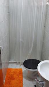 a bathroom with a shower with a toilet and a sink at 3 Kitnets in Rio das Ostras