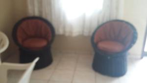 two chairs sitting in a living room next to a table at 3 Kitnets in Rio das Ostras