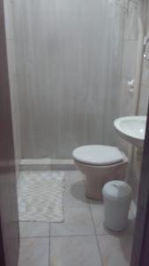 a bathroom with a toilet and a sink at 3 Kitnets in Rio das Ostras