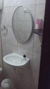 a bathroom with a white sink and a mirror at 3 Kitnets in Rio das Ostras