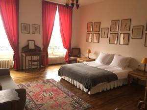 a bedroom with a bed with red curtains and a rug at B&B Le Jardin de Carco in Châtillon-sur-Seine