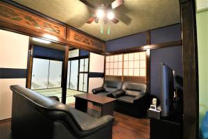 sala de estar con ventilador de techo, mesa y sillas en Smart House Riverside, en Ito