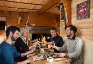 a group of people sitting around a table eating food at le Chal'heureux in Vars