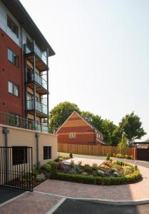 un bâtiment avec un jardin en face dans l'établissement House of Fisher - Equinox Place, à Farnborough