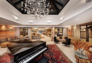 a living room with a piano in the middle at Hôtel Alexane in Samoëns