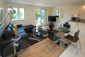 sala de estar con sofá, mesa y sillas en House of Fisher - Equinox Place en Farnborough