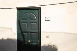 una puerta verde al lado de un edificio en San Pietro Holiday House en Scala
