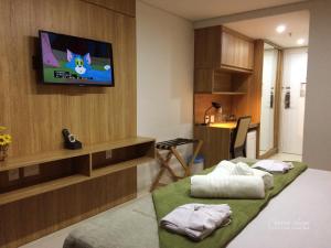 a room with two beds and a tv on the wall at Apartamento Itaipava Granja Brasil in Itaipava