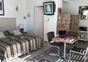 a bedroom with a bed and a desk with a laptop at Résidence hôtelière A TRAMA in Bonifacio