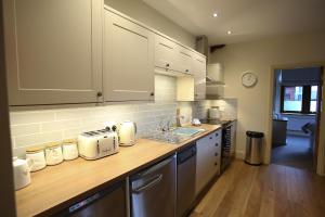 cocina con armarios blancos y encimera de madera en Grizedale View en Coniston