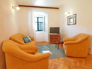 a living room with two chairs and a television at Apartment Kameo with terrace in Dubrovnik