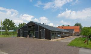 ein schwarzes Gebäude mit schwarzem Dach in der Unterkunft B&B Restaurant Maria Johanna Hoeve in Noordeloos