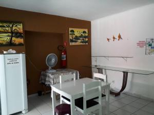 cocina con mesa, mesa blanca y sillas en Pousada Costa dos Corais, en Maragogi