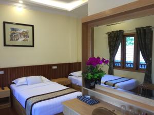 a hotel room with two beds and a mirror at Look Myanmar in Bagan +39 photos