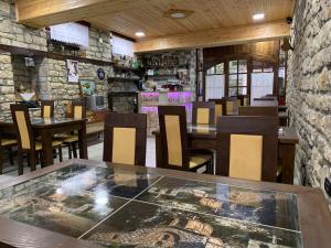 a restaurant with tables and chairs and a stone wall at Guest House Iljesa in Berat