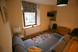 a living room with a blue couch and a window at Grizedale View in Coniston